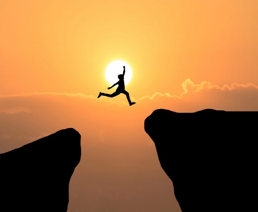 Courage man jump through the gap between hill ,Business concept