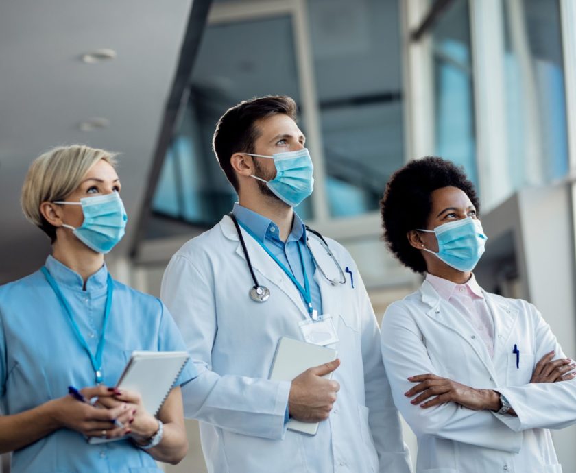 Team of medical experts with face masks at the hospital during c